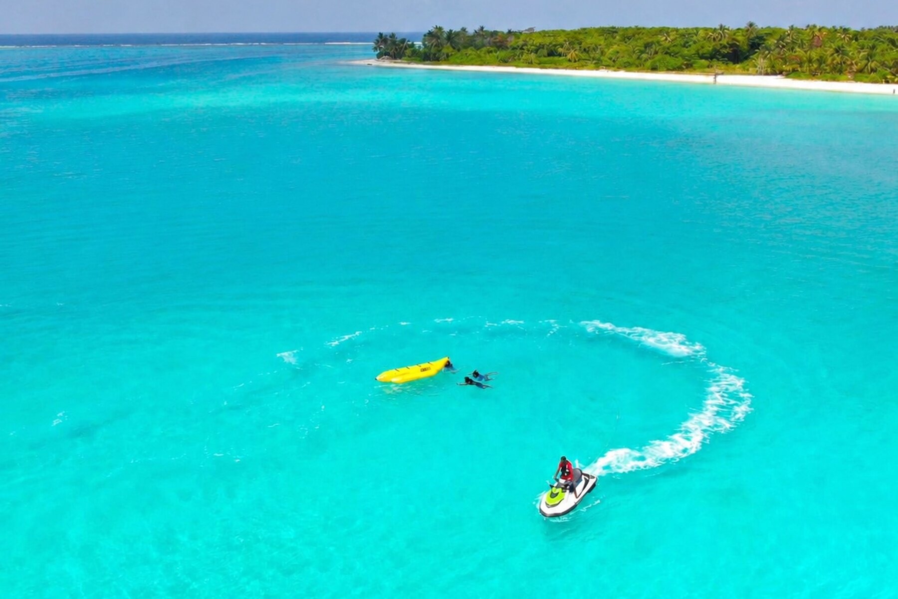 Jet skis and kayaks on a turquoise lagoon